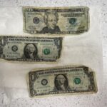 Two one-dollar bills and one twenty-dollar bill.
